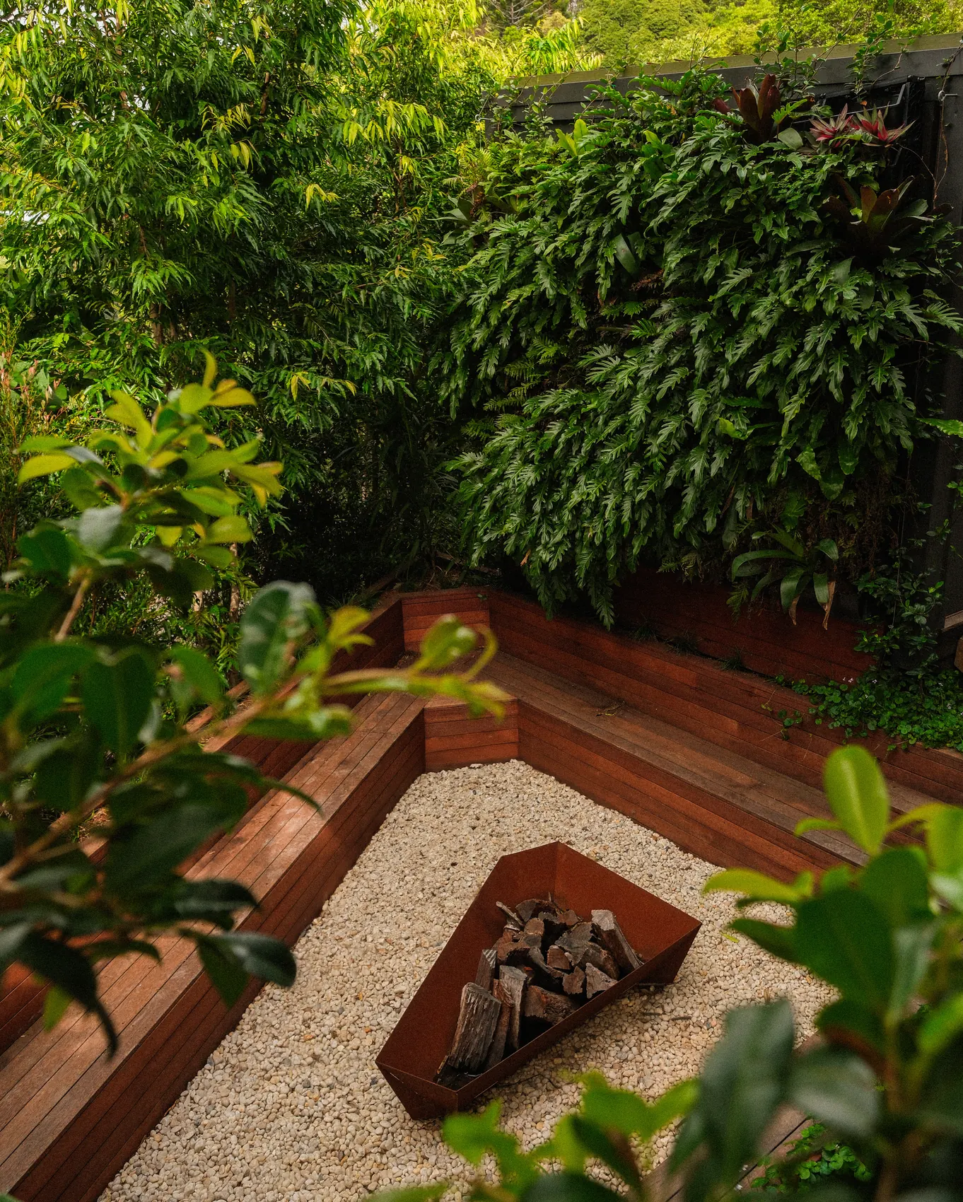 Timber bench seat and fire pit set in gravel