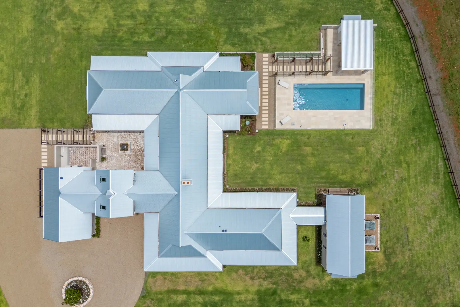 A rural property from directly above, showing the shaped levels, pool and paving